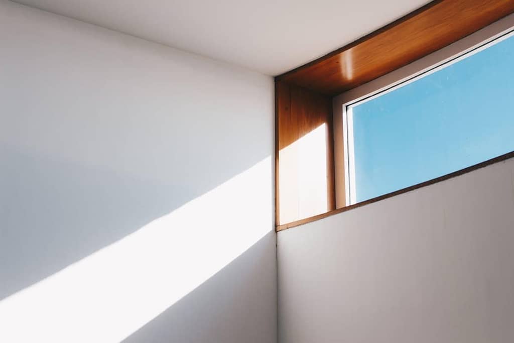 photo of a wooden window next to white walls