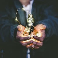 business ideas man holding incandescent bulb