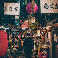 man walking between stores during night time