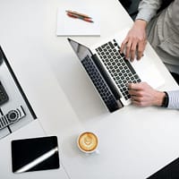 back-office person using laptop on white wooden table