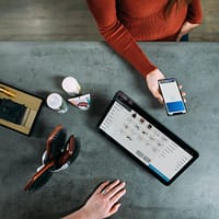 phone system person holding smartphone beside tablet computer