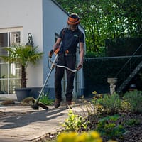 worker man in black t-shirt and blue denim jeans holding shovel