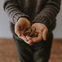 nonprofits copper-colored coins on in person's hands