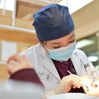 cosmetic dentistry woman doing dental on girl lying on bed