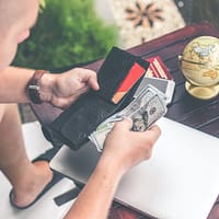 emergency loans person holding wallet and US dollar bills