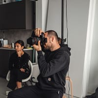 select the best photography studio man in black hoodie sitting on white plastic chair