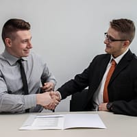 Business Consulting Partner two men facing each other while shake hands and smiling