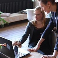 IT consulting company two woman looking at laptop screen