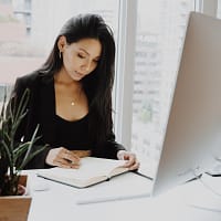 Generation Y woman in black blazer sitting at the table