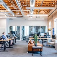 Office Moving Companies man in blue dress shirt sitting on rolling chair inside room with monitors