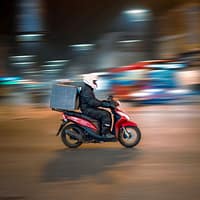 delivery business model man riding motorcycle on road during daytime