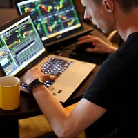 forex trading man sitting in front of the laptop