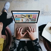 marketing mix person using microsoft surface laptop on lap with two other people