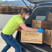 Delivery Management man in green t-shirt and blue denim jeans holding brown cardboard box