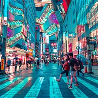 people walking on road near well-lit buildings