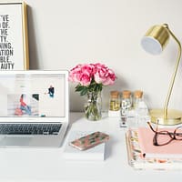 Business Fundraiser MacBook Air beside gold-colored study lamp and spiral books