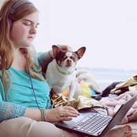 emotional marketing girl in blue jacket holding white and brown short coated puppy