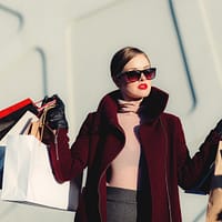 photo of woman holding white and black paper bags