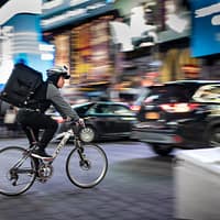 man riding bicycle near vehicles