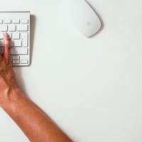 person typing on Apple Cordless Keyboard