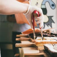 person holding brown wooden rolling pin