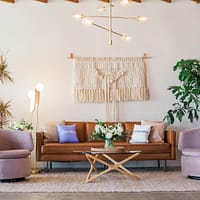 brown leather sofa and two pink sofa chair