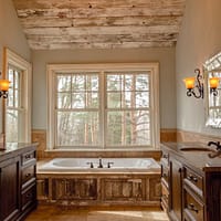 comfort room with white bathtub and brown wooden cabinets