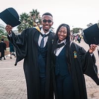 2 men in black academic dress standing on brown concrete floor during daytime