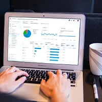 person using macbook pro on black table