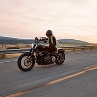 man on black cruiser motorcycle in highway