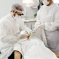 woman in white scrub suit holding white and green hose