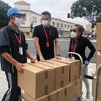 3 men in black polo shirt standing beside brown cardboard boxes