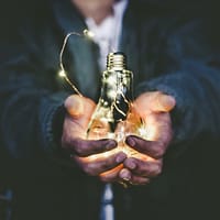 man holding incandescent bulb