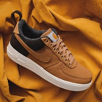 brown Nike sneaker on yellow textile