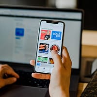 person using smartphone and laptop at the same time