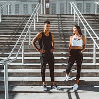 woman in black tank top and black pants standing on gray concrete stairs