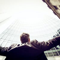 low-angle photography of man in the middle of buidligns