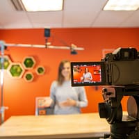 black video camera on brown wooden table