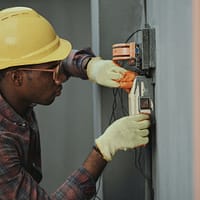 man in brown hat holding black and gray power tool