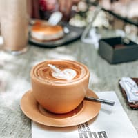 cappuccino in brown ceramic cup on saucer