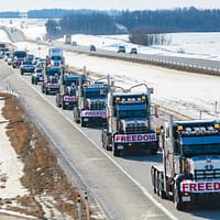 a long line of trucks driving down a highway