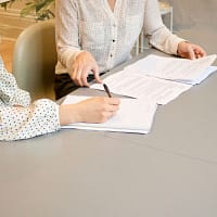 woman signing on a white paper