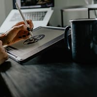 person holding silver fork on white paper