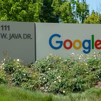 a google sign in front of some bushes and trees