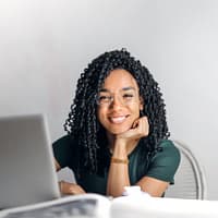 a woman smiling with a laptop