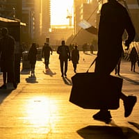 man walking on the field carrying bag