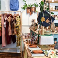 assorted-colored clothes on rack near brown wooden table