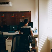 Person in Gray Shirt Sitting on Computer Chair