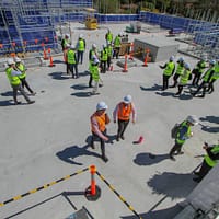 a group of construction workers standing on top of a building