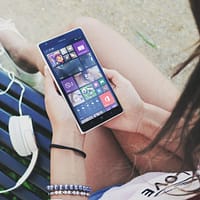 Woman Holding Turned Smartphone While Sitting on Bench Close-up Photography